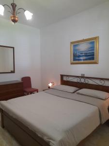 a bedroom with a large bed and a red chair at Casa da Emanuela in Drežnik Grad