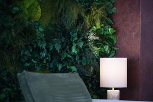 a table with a lamp in front of a green wall at Hotel Junior by OasiGroup Hotels in Rimini