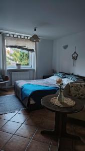 a bedroom with a bed and a table and a window at Willa Myśliwska Giżycko in Giżycko