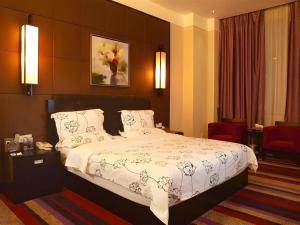 a bedroom with a large bed with white blankets and pillows at Behito Hotel in Dongguan