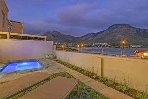 a house with a swimming pool and a fence at Bed and Breakfast Villa de la Mer in Hout Bay