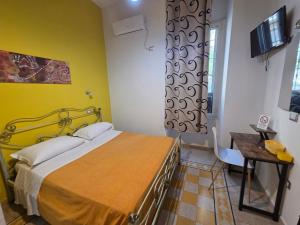 a bedroom with a bed and a desk in a room at B&B Enjoy Ercolano in Ercolano
