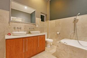 a bathroom with two sinks and a tub and a toilet at Bed and Breakfast Villa de la Mer in Hout Bay +43 photos