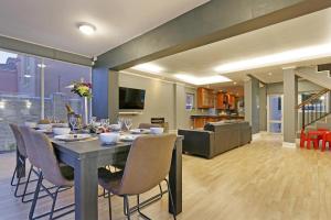 a dining room with a table and chairs and a kitchen at Bed and Breakfast Villa de la Mer in Hout Bay