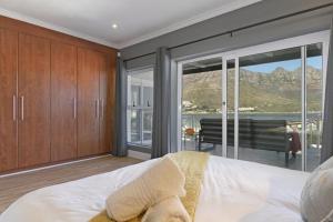 a bedroom with a bed and a large glass window at Bed and Breakfast Villa de la Mer in Hout Bay