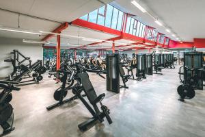 a gym with several rows of treadmills and machines at LF Sports & Spa Hotel in Hannover