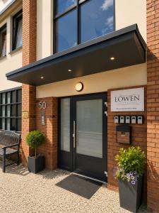 a building with a black door and a sign at LF Sports & Spa Hotel in Hannover