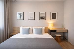 a bedroom with a bed with a desk and pictures on the wall at Into the town krabi in Krabi