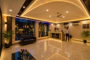 a lobby with a man standing in a room at Hotel Ronit Royal - Delhi Airport in New Delhi