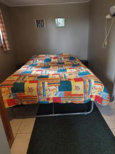a bed with a colorful quilt in a bedroom at Quo Vadis in Lengel