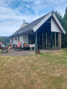 a house with a patio with two chairs and a table at Quo Vadis in Lengel