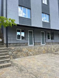 a building with windows and a stone wall at Апартаменти Атаман in Zhovtnevoye