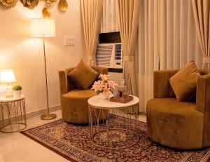 a living room with two chairs and a table at Peaceful Studio with Kitchen in New Delhi