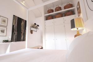 a white bedroom with a bed and a white cabinet at Senhora do Cabo Meco Homy Holidays in Sesimbra