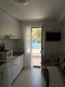 a kitchen with a door open to a patio at Apartments Boras in Cavtat