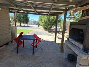 a patio with a table and chairs and a fireplace at Ossewa Rus in Sutherland +4 photos