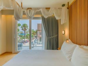 a bedroom with a large bed and a large window at San Vito Resort & Spa in San Vito lo Capo +100 photos