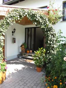 ein Torbogen mit weißen Blumen auf einem Haus in der Unterkunft Abendstille am Obstgarten mit Terrasse in Zapfendorf