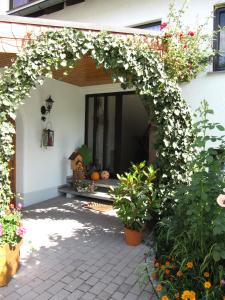 an archway with white flowers on a house at Abendstille am Obstgarten mit Terrasse in Zapfendorf