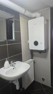 a bathroom with a sink and a soap dispenser on the wall at Holiday home Pustodol in Donja Stubica