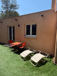 a group of chairs and a table in a yard at A Casa Rosa in Omessa