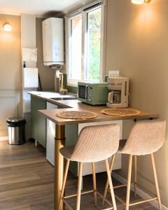 a kitchen with a counter with two chairs and a microwave at A Casa Rosa in Omessa