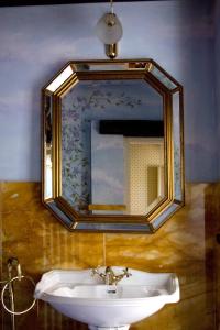 - un miroir au-dessus d'un lavabo dans la salle de bains dans l'établissement Villa Althea, à Mango