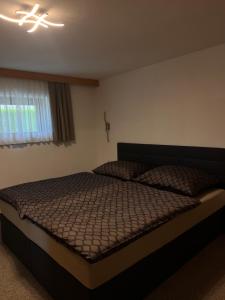 a bedroom with a bed and a light on the ceiling at Appart Leni in Pfunds