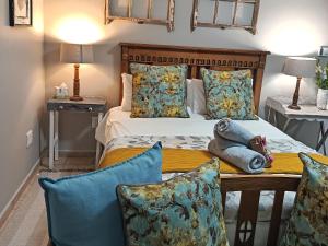 a bedroom with a bed and a table with pillows at Nouvelle Vie Self-catering Accommodation in Reebok