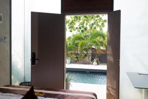 a bedroom with a door open to a pool at TUNA Hiriketiya - Luxury Resort & Pool Retreat in Hiriketiya