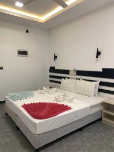 a large white bed with a red blanket on it at Seaside Villa in Dhiffushi +44 photos
