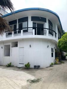 a white building with a balcony on top of it at Seaside Villa in Dhiffushi