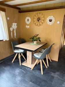 a wooden table with chairs and a plant on it at Mobile home Le paradis dans la nature in Bourg-Saint-Pierre +6 photos