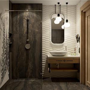 a bathroom with a sink and a shower with a mirror at Ku Dolinie in Kościelisko