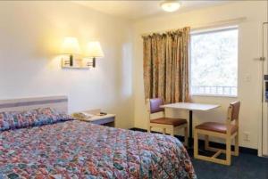 a hotel room with a bed and a table and a window at Loyalty Inn in Brice