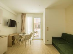 a living room with a green couch and a table at San Vito Resort & Spa in San Vito lo Capo