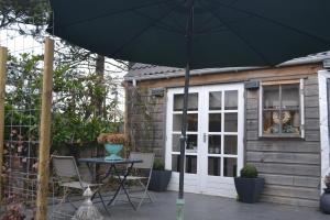 un patio con mesa y sombrilla en Studio@25, en Zandvoort