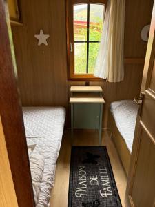 a small room with two beds and a window at Mobile home Le paradis dans la nature in Bourg-Saint-Pierre