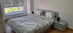 a bedroom with a bed with towels on it at Apartman Tara Jagodina, ima free parking u garazi in Jagodina
