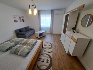 a bedroom with a bed and a living room at Most Apartmanok in Sátoraljaújhely