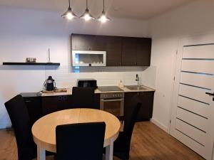 a kitchen with a wooden table and a kitchen with a tablektop at Most Apartmanok in Sátoraljaújhely