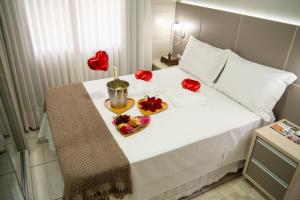 a bed with red flowers on top of it at Sítio Monte Frederico in Nova Trento +11 photos