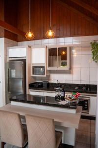 a kitchen with a black counter top and appliances at Sítio Monte Frederico in Nova Trento