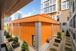 an orange building in the middle of a city at NOVA HOME Apartments - NEST ONE, Panoramic Views, Tashkent City in Tashkent