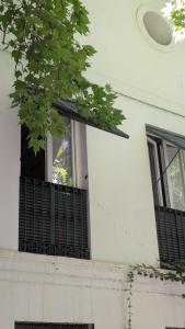 a window of a white building with black shutters at Hotel del Balneario in Tolox