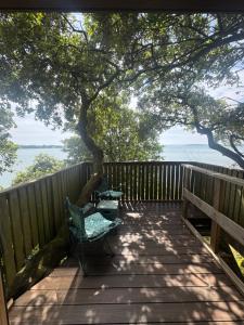 a deck with a tree and two chairs on it at Harbour view Tree House in Cobh