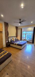 a bedroom with two beds and a ceiling fan at The White Yak Hotel in Leh
