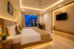 a hotel room with a bed and a window at Hotel Ronit Royal - Delhi Airport in New Delhi