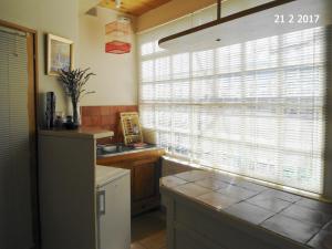 a kitchen with a sink and a window with blinds at La Petite Bergerie in Drôme Provençale in Rottier
