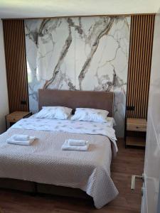a bedroom with a bed with two towels on it at Golubović Apartments in Žabljak